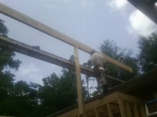 Carpenter setting a ridge beam over a new addition frame — Ice Dam Removal by Roofing Brothers in Koosharem