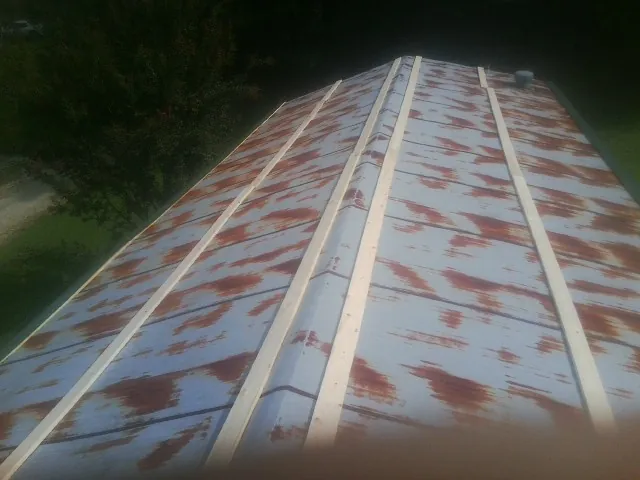 Rusted metal roof panels with new wood purlins before replacement — Storm Damage Roof Repair in Koosharem by Roofing Brothers