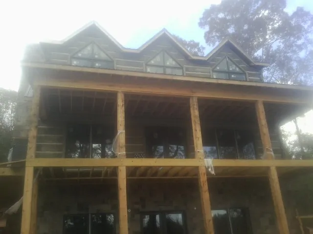Dormers and porch framing on a large log home under construction — Roof Coating work by our crew in Koosharem