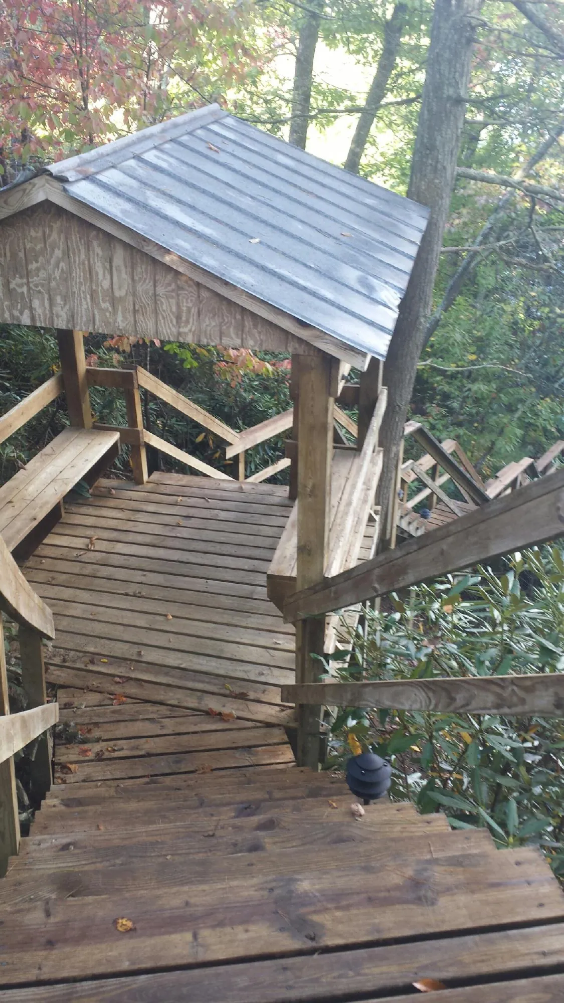 Metal roofed shelter over wooden steps on a wooded walkway — Skylight Repair & Installation work by our crew in Koosharem